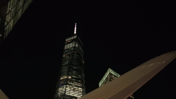 クローズ アップ、低視野角: 関連メインの建物で窓が照らされた複雑な再建の世界貿易センターの夜。ロウアー ・ マンハッタンのダウンタウンのビジネス地区、ニューヨークのフリーダム タワーは有名な - 映像、動画
