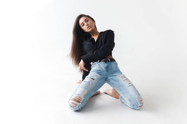 Young cool hipster girl in black shirt and blue banana jeans on white background. Fashionable modern style - Φωτογραφία, εικόνα
