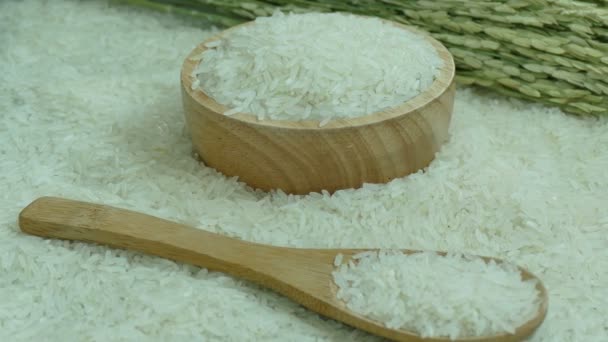 ακατέργαστο ρύζι σε ξύλινο μπολ και τα κουτάλια, βίντεο  - Πλάνα, βίντεο