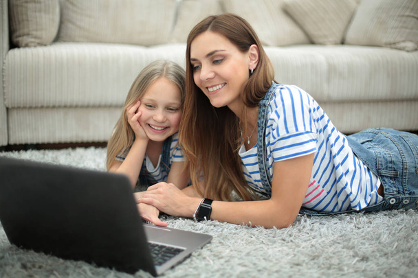 mère et fille utilisant un ordinateur portable dans leur maison - Photo, image