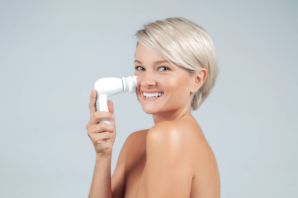 Happy woman cleaning face skin with brush and foam. Natural cosmetic. Facial beauty treatment concept.  - Foto, Bild