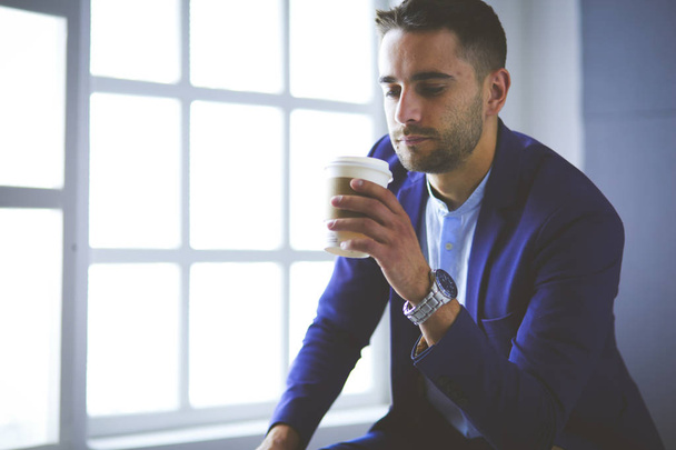 Young business man drinking a cup of coffee or tea - Φωτογραφία, εικόνα