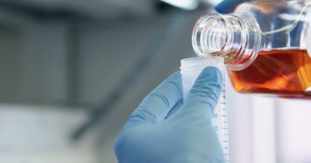 Close-up of scientist pouring chemical in vaccine container in laboratory 4k - Materiał filmowy, wideo