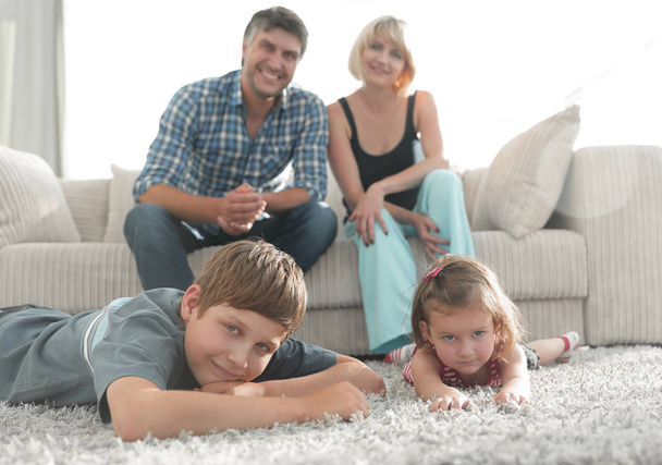 Portrait of happy family sitting together in living room - Fotoğraf, Görsel