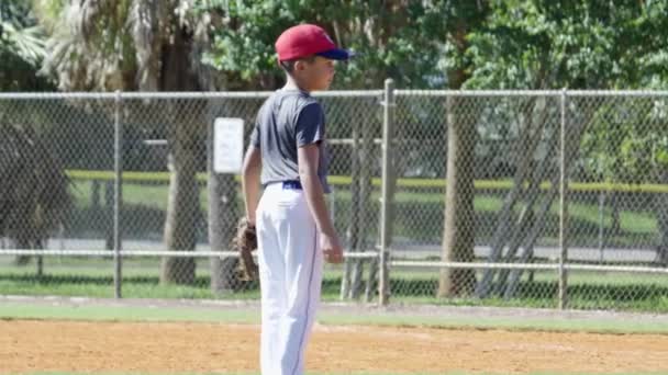 Movimiento lento del niño con uniforme y guante en la práctica de béisbol
 - Imágenes, Vídeo