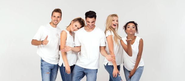 Group of young multi-ethnic attractive people wearing white shirts, smiling and having fun together, posing in studio.  - Foto, Imagen