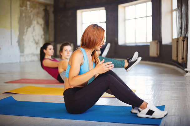Group of women rest on mats between exercise sets - Photo, Image