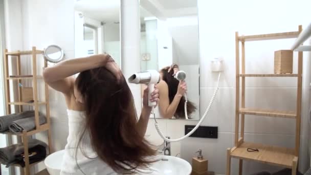 Hajápolás. Szárítás, hosszú haj, a fürdőszoba hajszárítóval felszerelt nő - Felvétel, videó