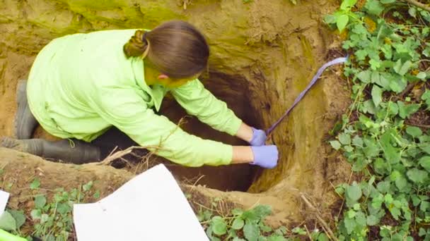 Nainen ekologi ottaa näytteitä maaperän
 - Materiaali, video