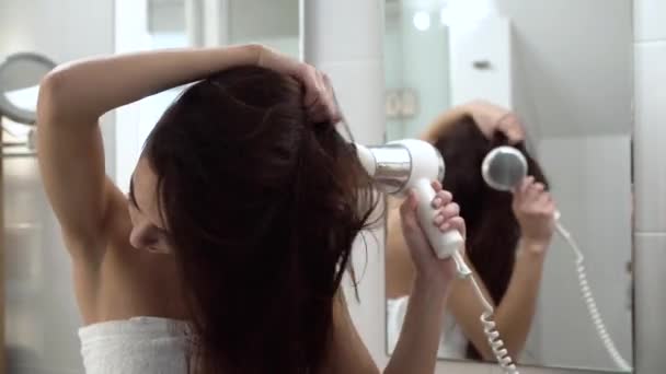 Hajápolás. Szárítás, hosszú haj, a fürdőszoba hajszárítóval felszerelt nő - Felvétel, videó