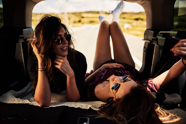 Deux filles allongées dans le coffre et se reposant de conduire
. - Photo, image