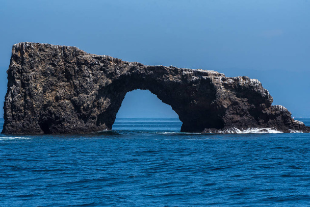 Rock Anacapa Adası'nın doğu ucunda küçük dalgalar karşı temel bir tipik mavi gökyüzü gün çökmesini ile kemer. - Fotoğraf, Görsel