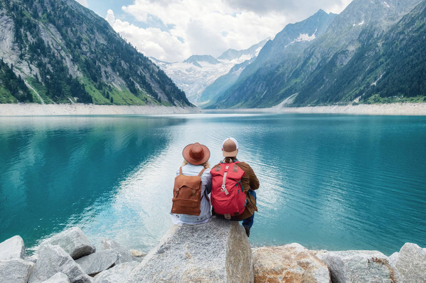 Travelers couple look at the mountain lake. Travel and active life concept with team. Adventure and travel in the mountains region in the Austria - Foto, Imagen