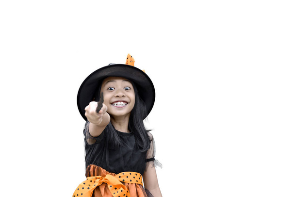 Smiling asian witch girl with magic wand isolated over white background - 写真・画像