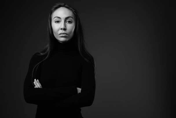 Young beautiful businesswoman wearing long sleeved turtleneck dr - 写真・画像