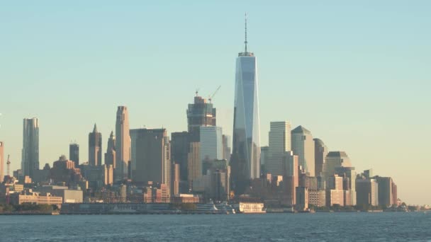 New York City Skyline berühmten Wahrzeichen beleuchtet gegen den goldenen Abendhimmel. ikonischer One World Trade Galopp, der die umliegenden Wolkenkratzer und Bürogebäude in seiner gläsernen Fassade widerspiegelt - Filmmaterial, Video