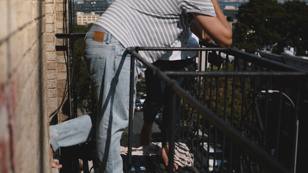 schönes multiethnisches romantisches Paar, das barfuß zusammen steht, sich umarmt, sich sanft küsst auf dem schönen sonnigen New Yorker Balkon. - Filmmaterial, Video