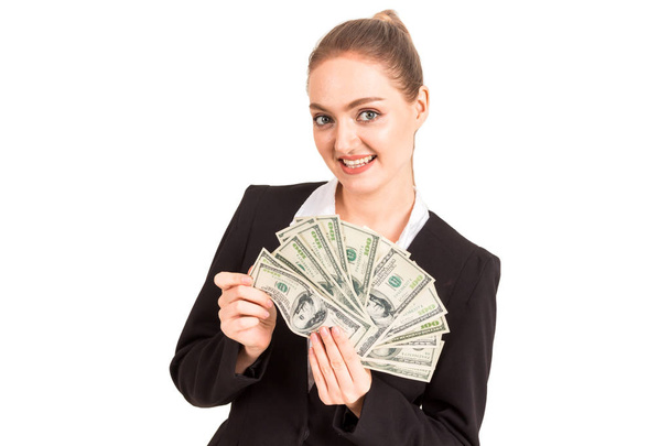 Kaunis ja menestyksekäs onnellinen liikenainen mustassa puvussa pitäen rahan dollarin seteleitä eristyksissä valkoisella taustalla
 - Valokuva, kuva