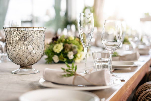 Wedding Banquet or gala dinner. The chairs and table for guests, served with cutlery and crockery. Covered with a linen tablecloth runner. party on terrace - Photo, image
