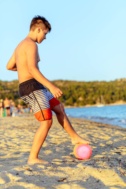 Schattig kind spelen voetbal op het strand tijdens zomervakantie - Foto, afbeelding