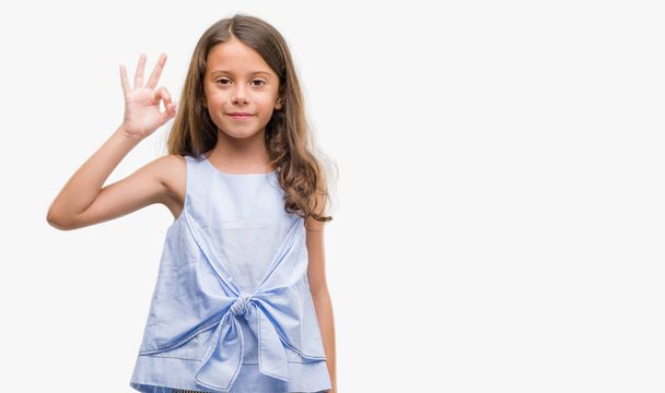 Brunette hispanic girl smiling positive doing ok sign with hand and fingers. Successful expression. - Foto, imagen