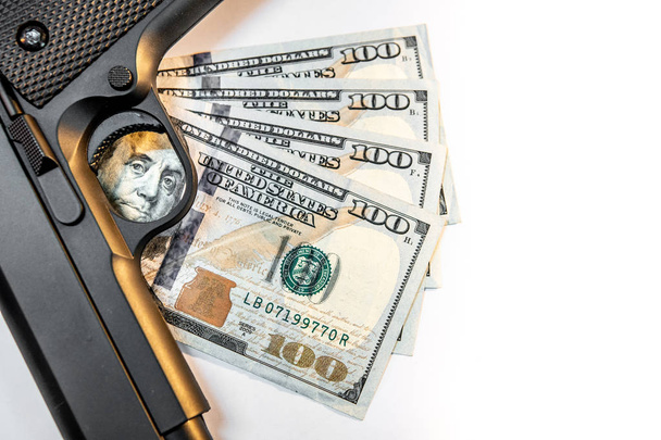 Μαύρο πιστόλι σε χαρτονομίσματα του δολαρίου. Φόντο παράνομων όπλων διακίνησης έννοια - Φωτογραφία, εικόνα