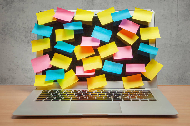 Laptop volledig weergeven in de herinneringen van gekleurde stickers op tafel met grijze muur - Foto, afbeelding