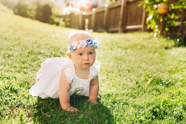 Baby at summer outside. Adorable little girl on green nature background. Image of childhood. Parents and activity with kid outdoors. Beautiful happy child have fun on grass of meadow. - Foto, afbeelding