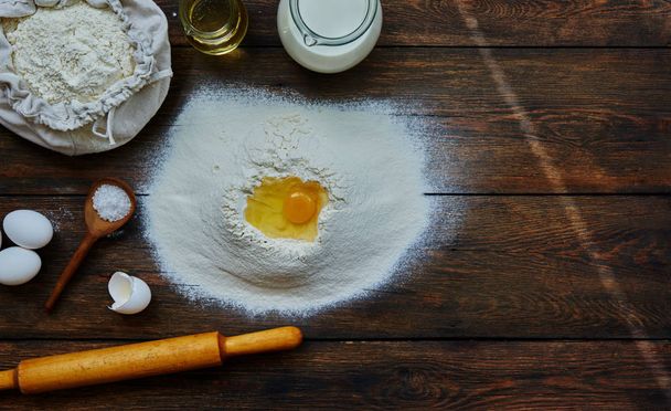 Healthy baking ingredients. Dough recipe ingredients. Flour, sugar, egg, butter on vintage wood table. Ingredients and kitchen items for baking cakes. Top view. Rustic background with text space. - Foto, Bild
