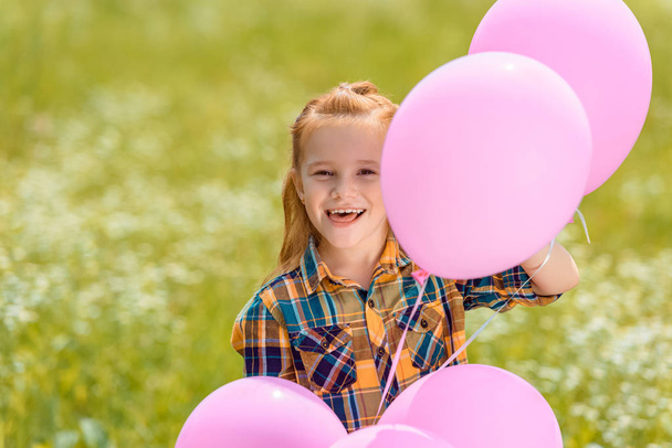 portrait of happy child with pink balloons in summer field - Fotografie, Obrázek