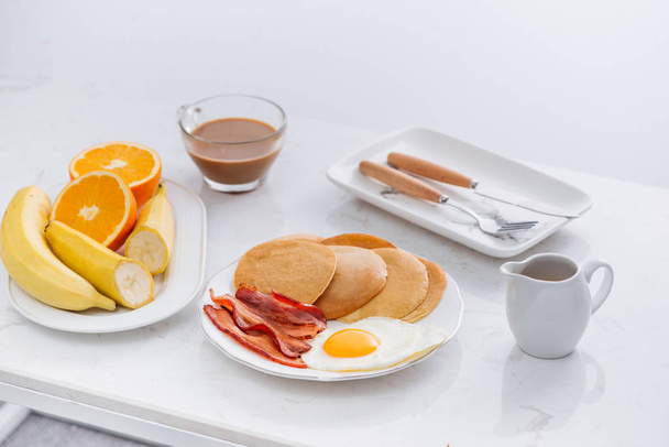 Colazione americana completa sana con uova pancetta e pancake
 - Foto, immagini