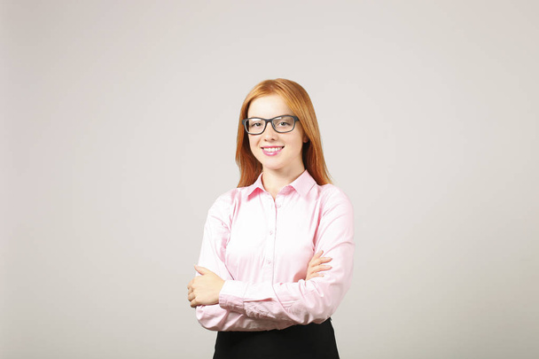 Confident successful mixed race caucasian - african american business woman in glasses, standing with folded hands and smiling at camera, isolated on white background - Photo, image
