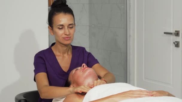 Wesoły masażystka uśmiechający się podczas pracy z klientem - Materiał filmowy, wideo