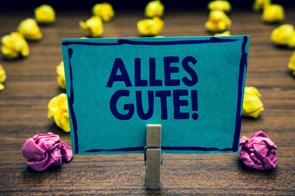 Text sign showing Alles Gute. Conceptual photo german translation all the best for birthday or any occasion Clothespin holding blue paper note crumpled papers several tries mistakes - Photo, Image
