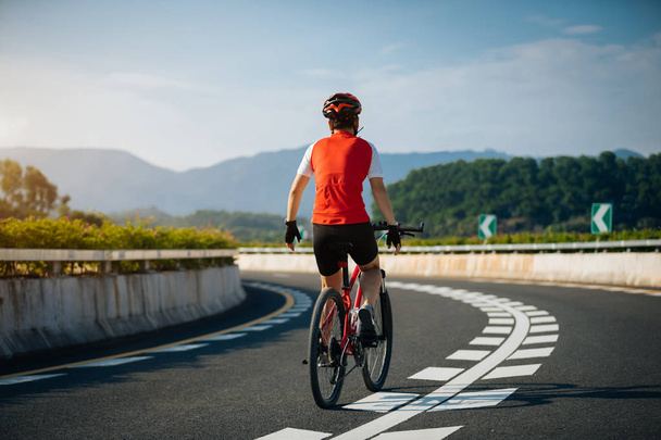 Велосипедистка їде на гоночному велосипеді по дорозі
 - Фото, зображення