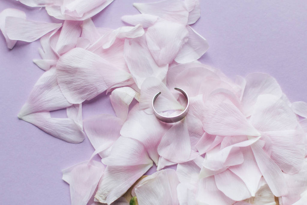 pétalas de flores rosa concurso e anel sobre fundo rosa
 - Foto, Imagem