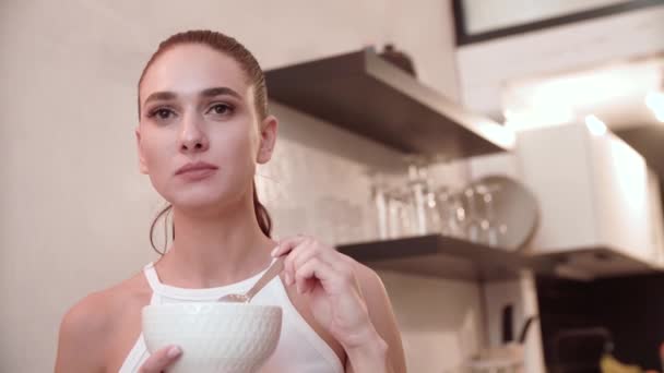 Mooie vrouw eten uit kom op keuken Closeup - Video