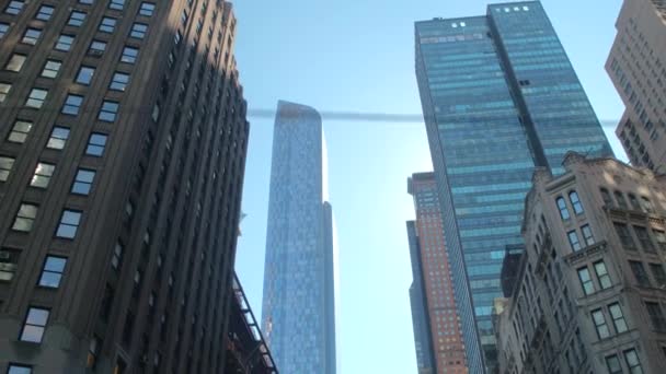 Szoros, alacsony szög: Vezetés lakóépületek elfoglalt New York-i belvárosi üzleti negyedében-, nagy üveges felhőkarcolók Manhattan szomszédságában és nagy, modern irodaházak - Felvétel, videó