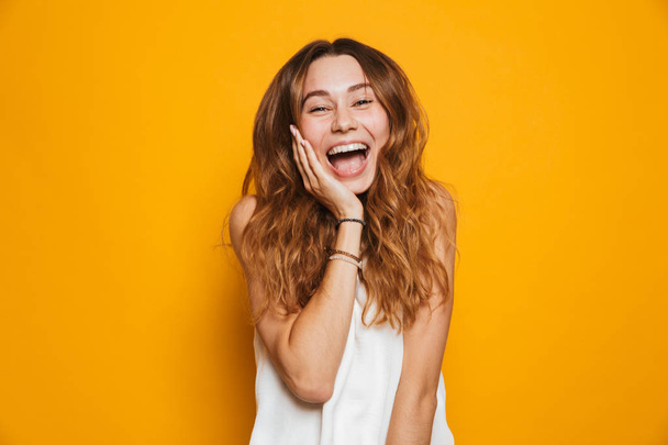 Portrait of a cheerful young girl screaming isolated over yellow background - Photo, image