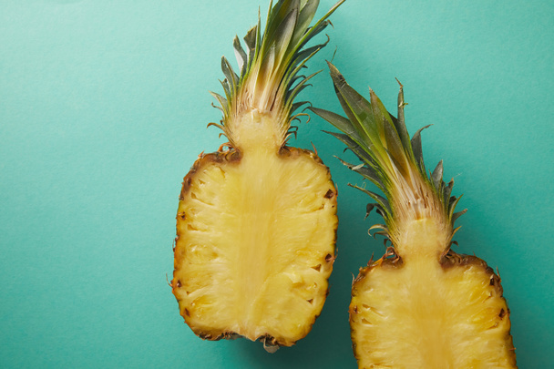 Ansicht der geschnittenen Ananas auf türkisfarbener Oberfläche - Foto, Bild