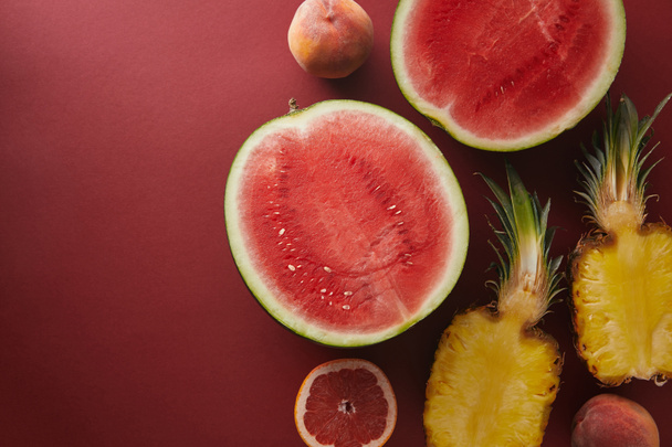 top view of cut fruits on red surface - Photo, image
