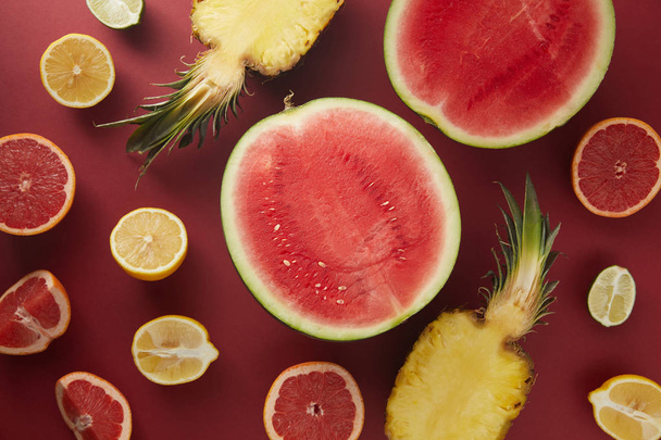 vista superior de apetitosas frutas crudas en la superficie roja
 - Foto, imagen