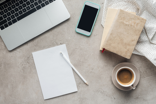 pohled shora kávy s notebook a smartphone s prázdnou obrazovkou na betonový podklad s prázdný papír - Fotografie, Obrázek