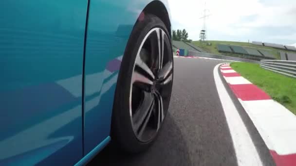 Close Up niski kąt widzenia: Nowy niebieski osobowych samochód sportowy bardzo szybkiej jazdy kolanach i konkurencyjnych na luksusowych Hungaroring wyścig śledzić na ring. Przekroczenie prędkości biały wyścigowy na tor wyścigowy i wiodącą rolę - Materiał filmowy, wideo