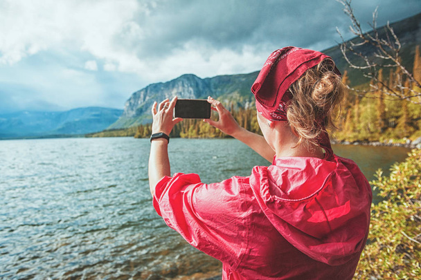 Tourist woman taking photo of lake and mountain. Tourism concept - Photo, Image