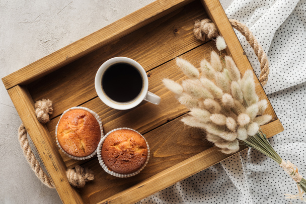 vue de dessus de tasse de café avec muffins et lagurus ovatus bouquet sur la surface du béton
 - Photo, image
