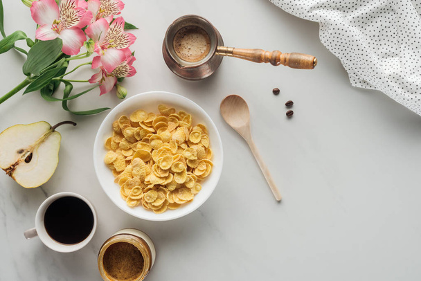 top view of bowl of cereal with coffee and flowers bouquet on white - Photo, Image