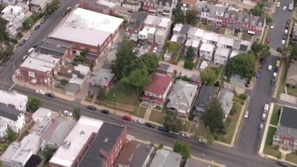 AERIAL: Flying above rooftops of colorful built together rowhouses and single family detached houses in densely populated suburban town. Structured real estate development of residential buildings - Footage, Video