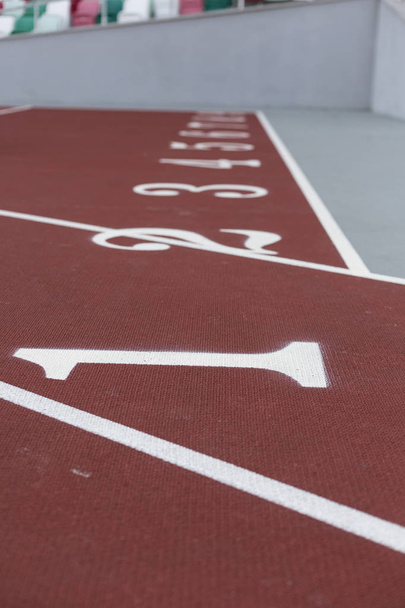 Piste de sport rouge pour courir sur le stade avec des numéros. Courir mode de vie sain concept. Fond sportif texture abstraite
 - Photo, image