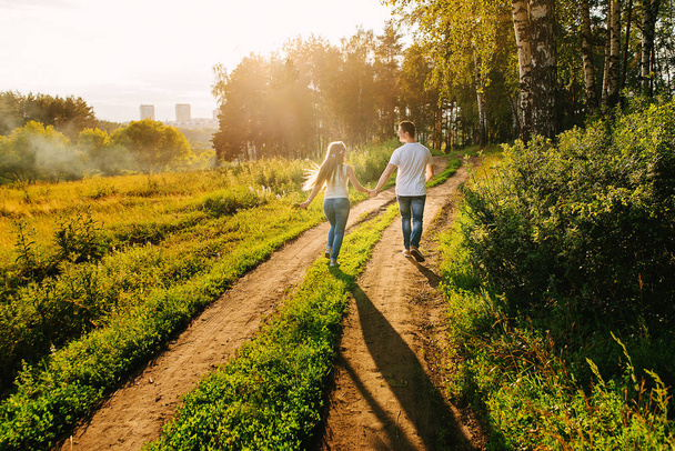 Happy couple walking together in a green countryside - Φωτογραφία, εικόνα